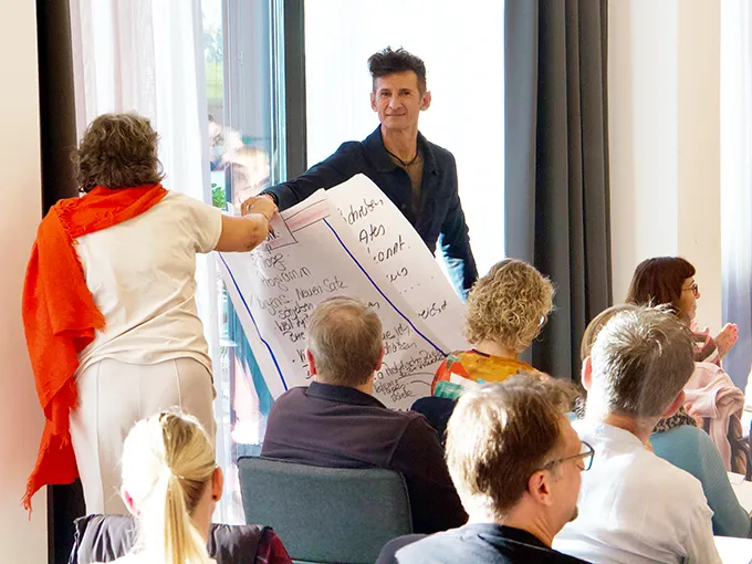 Robert Stark verteilt Flipchart-Blätter für den guten Zweck