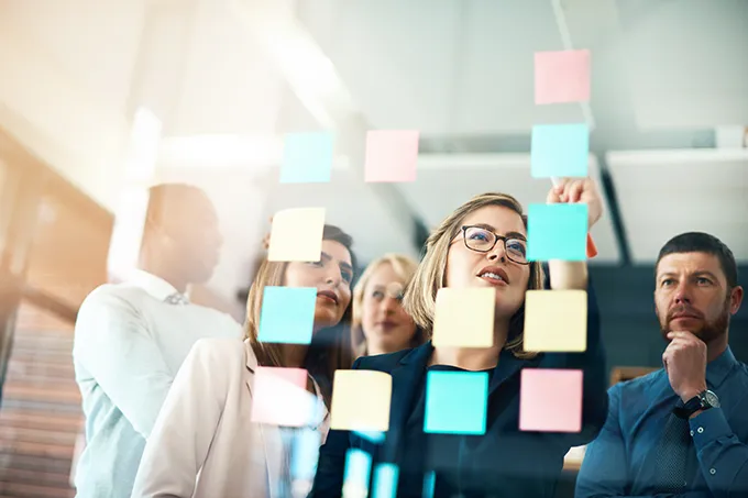 Büro, Team steht vor einer Zettelwand