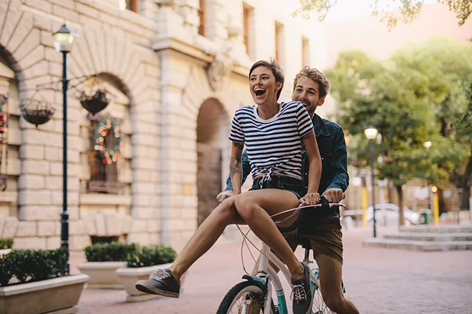 Junger Mann und junge Frau gemeinsam auf einem Fahrrad